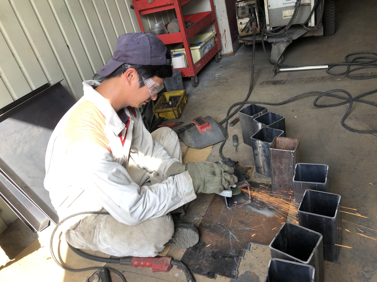 合資会社蓬莱自動車工作所 整備士が鈑金塗装作業を行っている画像